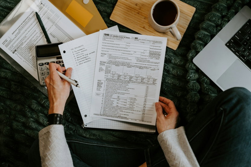 person-reviewing-documents-with-calculator-and-laptop-.jpg Person reviewing documents with calculator and laptop.